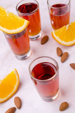 Açık arkaplandaki bardakta şeffaf kahverengi sıvı. Seçici odak.