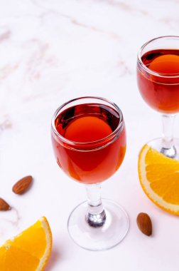 Açık arkaplandaki bardakta şeffaf kahverengi sıvı. Seçici odak.