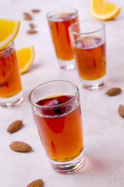 Açık arkaplandaki bardakta şeffaf kahverengi sıvı. Seçici odak.