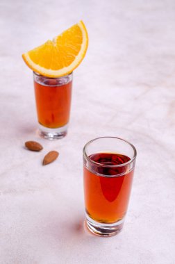 Açık arkaplandaki bardakta şeffaf kahverengi sıvı. Seçici odak.