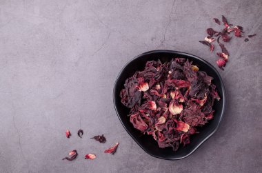 Koyu arkaplanda seramik bir kasede kurumuş amber yaprağı. Üst Manzara. Boşluğu kopyala.