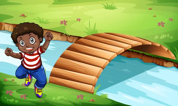 Un niño negro feliz cerca del puente de madera — Vector de stock