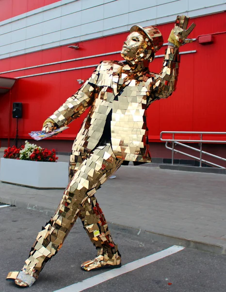 Minsk. Beyaz Rusya. 18 Haziran 2019. Sıradışı altın takım elbiseli ve şapkalı bir animasyon sanatçısı festivalde insanları eğlendiriyor..