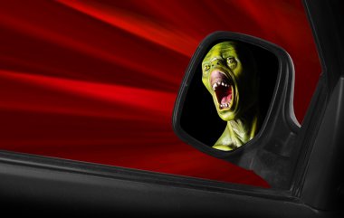 Screaming zombie in a speedy car. clipart