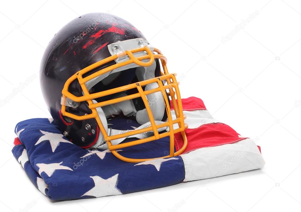 Old scratched football helmet on a american flag.