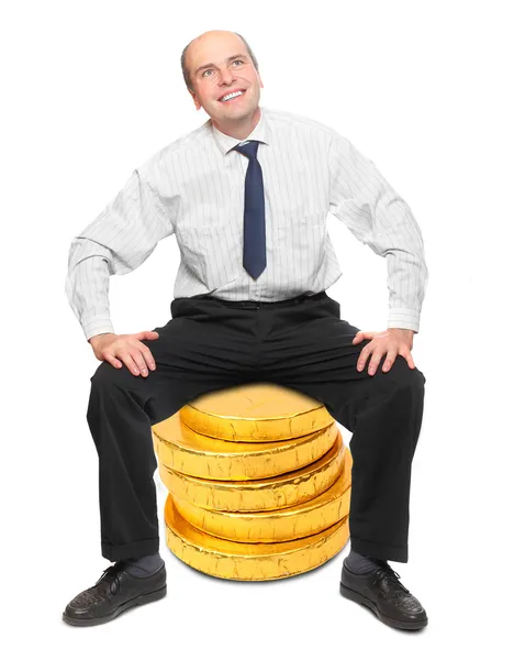 Successful businessman sitting on a golden coins. — Stock Photo, Image