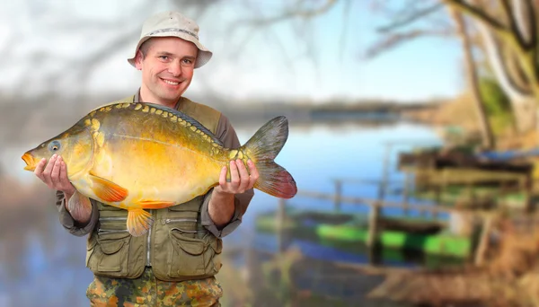 Il pescatore con la sua grande carpa in un bellissimo lago della Boemia meridionale. Repubblica ceca, Europa . — Foto Stock