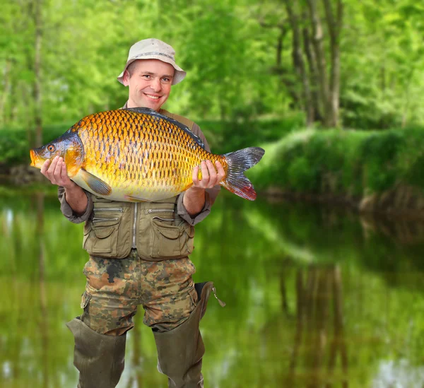 El pescador con su gran carpa en un hermoso río . — Foto de Stock