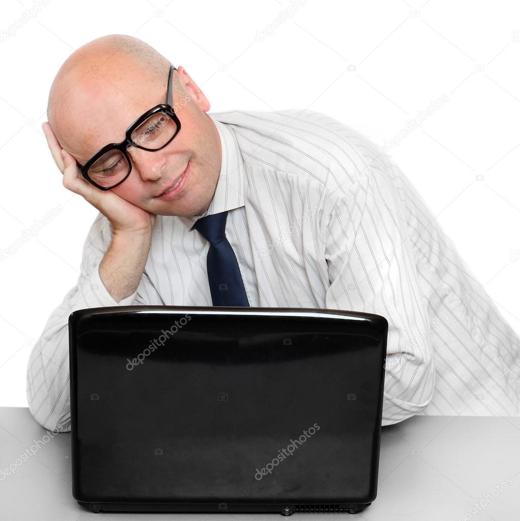 Sleeping businessman with laptop on a desk in the office