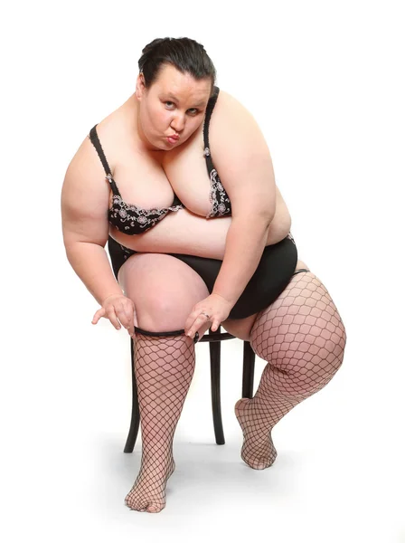 Overweight woman dressed in underwear posing in the studio. Stock Image