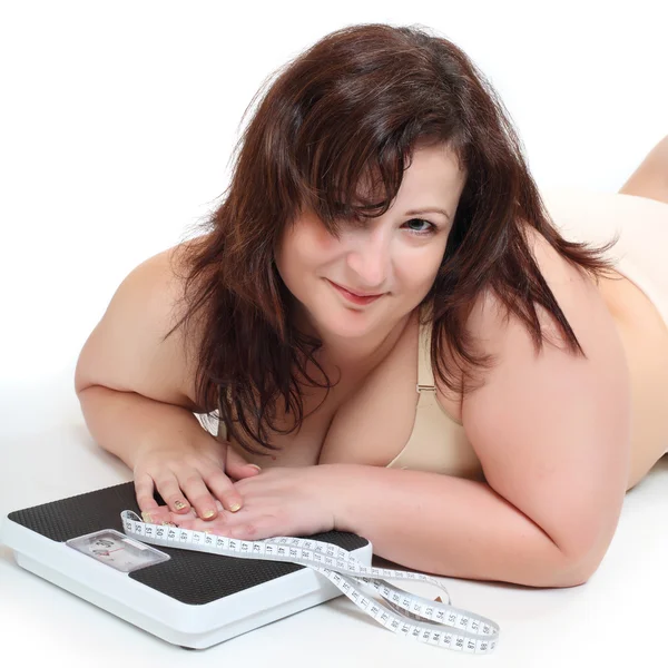 Overweight woman with a weighing machine and measure tape. — Stock Photo, Image