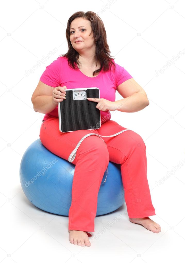 Overweight woman with weighing machine.