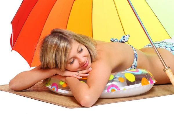 Giovane donna in costume da bagno a riposo sotto un ombrellone . — Foto Stock