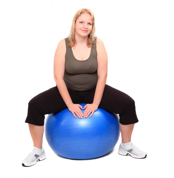 Tiro de una mujer joven con sobrepeso con bola azul sobre un fondo blanco . — Foto de Stock