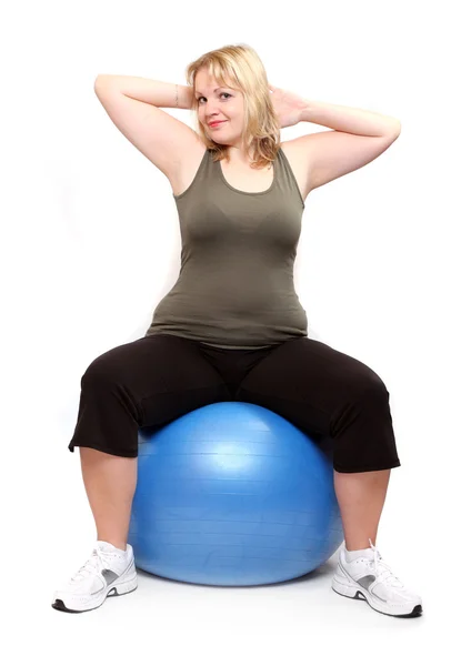 Giovane donna sovrappeso con palla fitness blu — Foto Stock