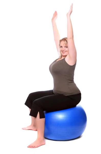 Übergewichtige junge Frau mit blauem Foutness-Ball bei Übungen — Stockfoto