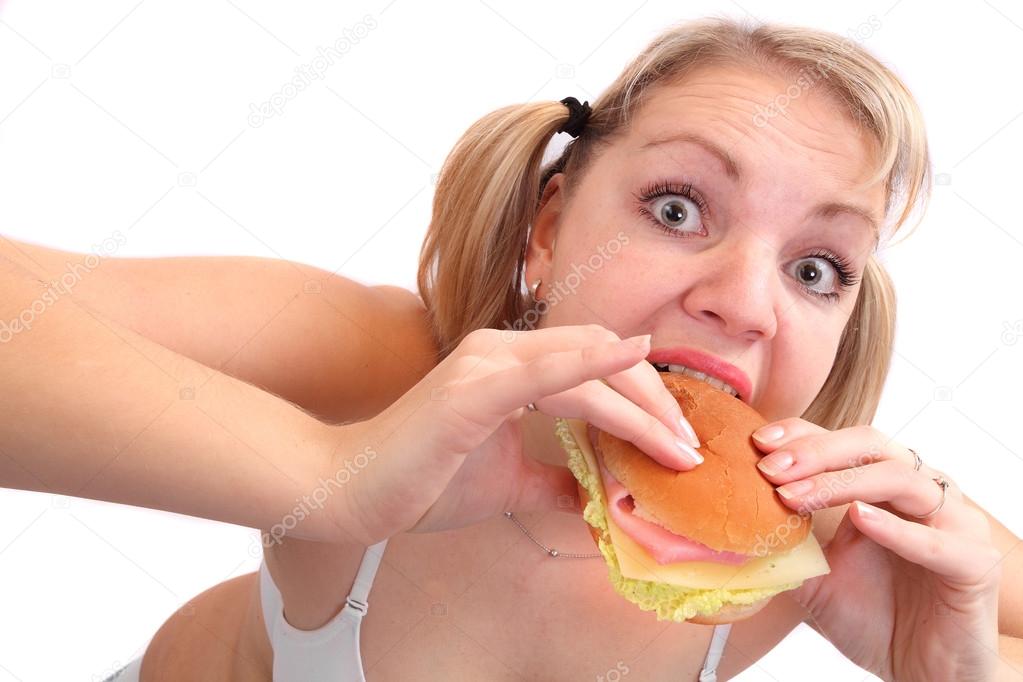 Overweight woman eating big sandwich with ham.