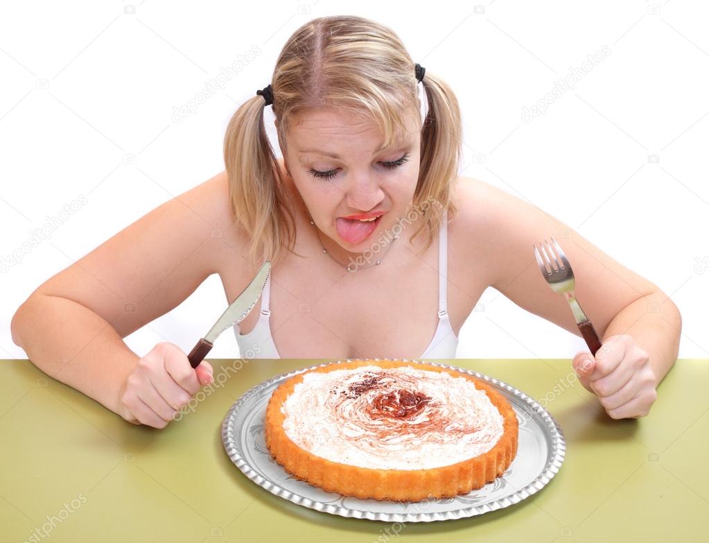 Overweight woman eating sweet cream cake.