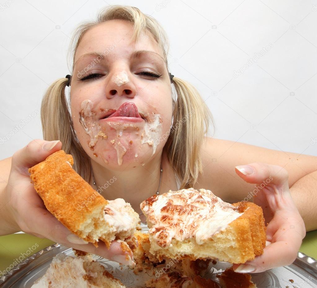 Overweight woman eating cream cake.