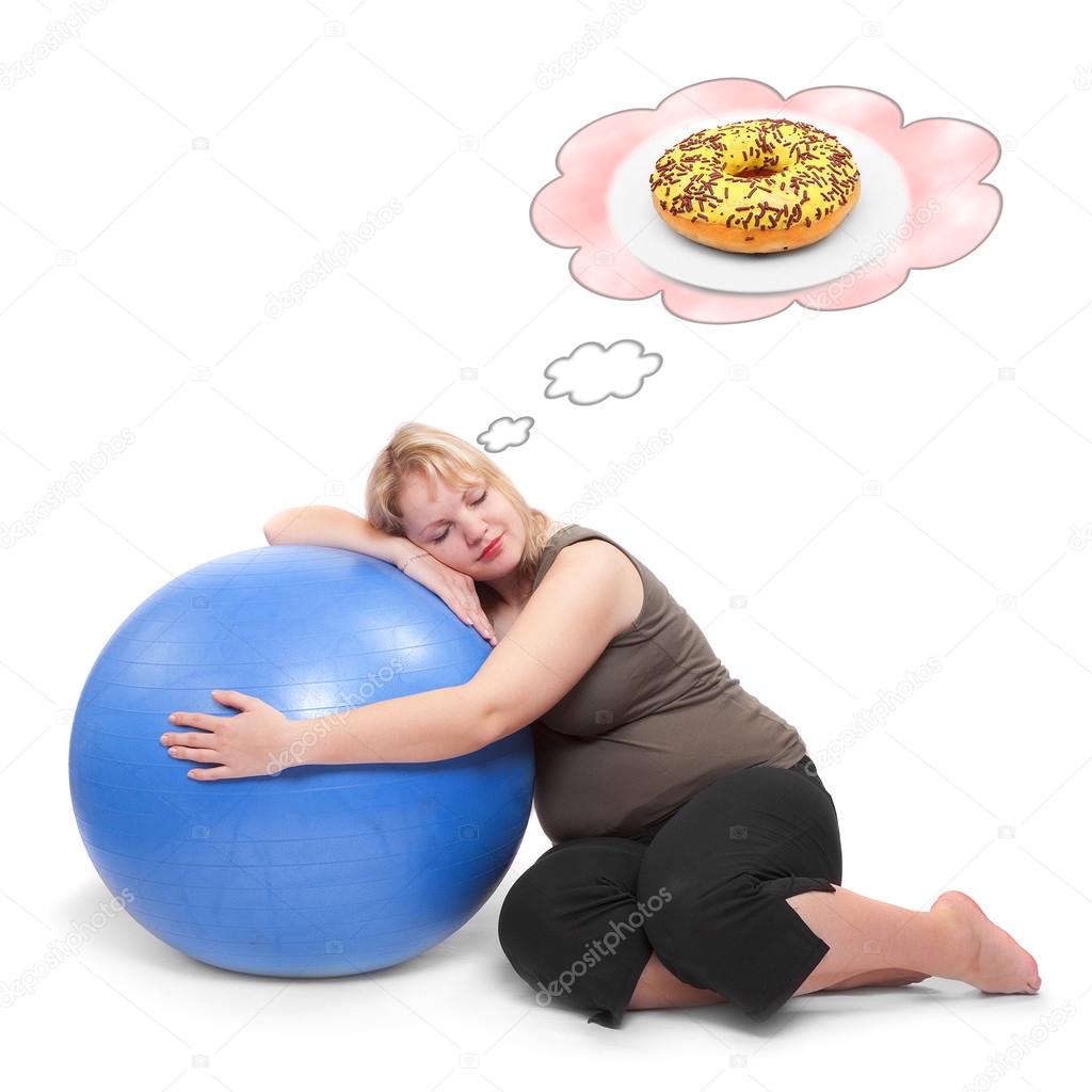Hungry overweight woman practising with fitness ball