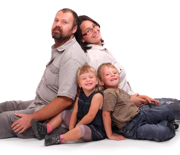 Família feliz descansando sobre um fundo branco — Fotografia de Stock