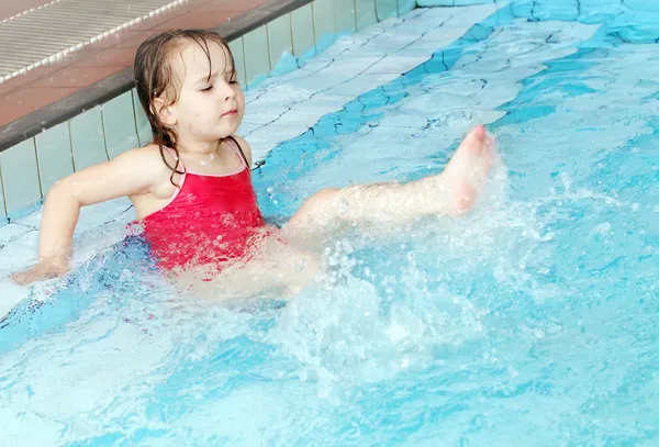 Szczęśliwa dziewczynka pływanie w basenie — Zdjęcie stockowe