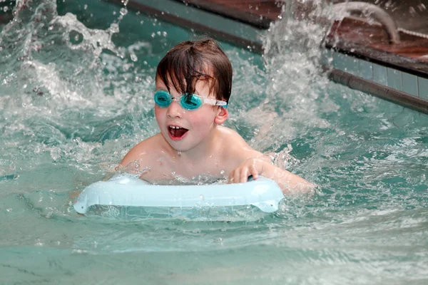 Pojke bada i en pool. — Stockfoto