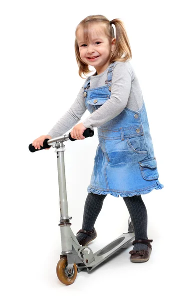 Klein meisje haar kinderen scooter rijden. — Stockfoto