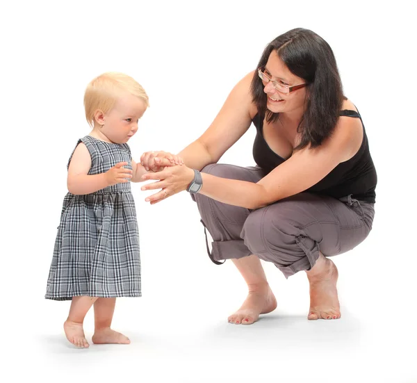 Baby flicka gör sina första steg med mamma hjälp. — Stockfoto