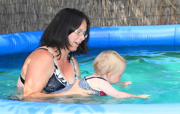 Felice famiglia nuotare in una piscina . — Foto Stock