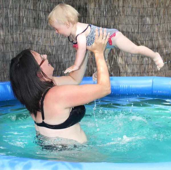 Lycklig familj bada i en pool. — Stockfoto