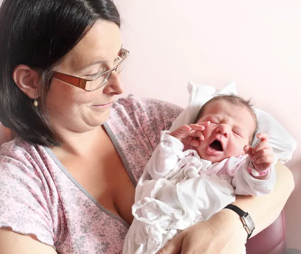 Madre joven con su bebé recién nacido. Cierre con DOF poco profundo . — Foto de Stock