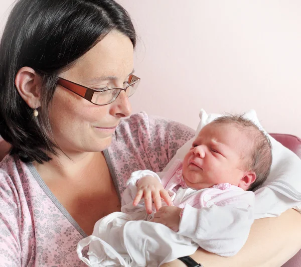 Jonge moeder met haar pasgeboren baby. Close-up met ondiepe dof. — Stockfoto