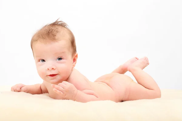 Happy baby ligger på sängen. — Stockfoto