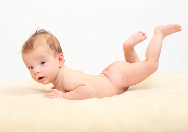 Bebê feliz deitado na cama . — Fotografia de Stock