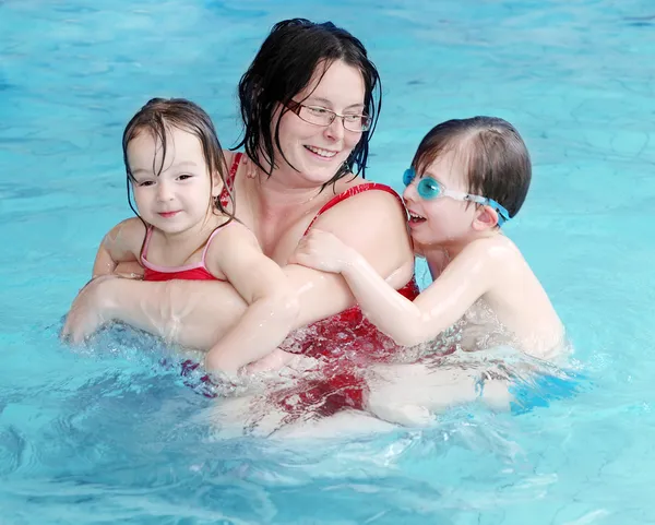 Glückliche Familie schwimmt in einem Pool. lizenzfreie Stockbilder