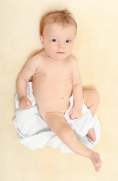 Happy baby in diaper lying on the bed. Stock Photo