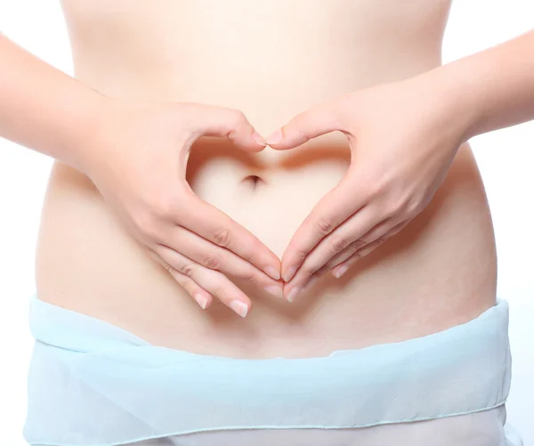 Liebe und neues Lebenskonzept. Frauenhände bilden ein Herzsymbol auf dem Bauch — Stockfoto