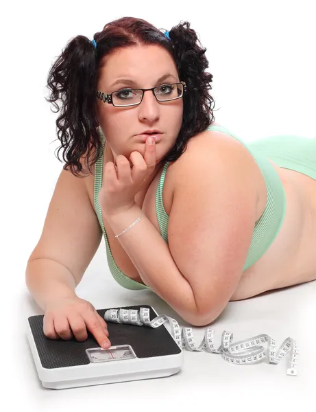 Overweight woman with a weighing machine. — Stock Photo, Image