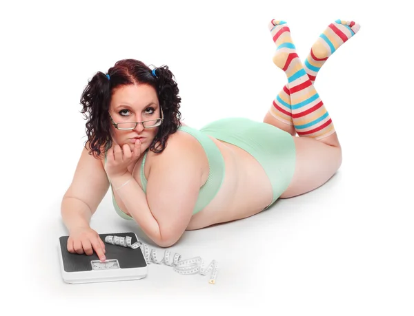 Overweight woman with a weighing machine. — Stock Photo, Image