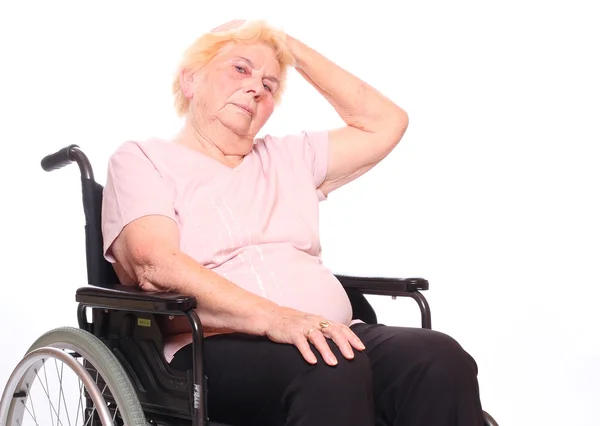 Ältere querschnittsgelähmte Frau sitzt im Rollstuhl — Stockfoto