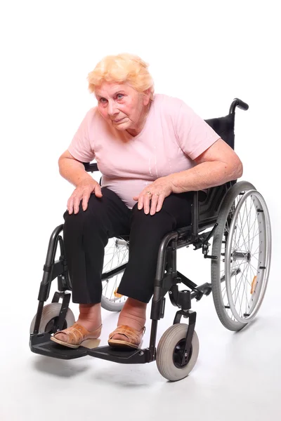 Elderly paraplegic woman sitting in a wheelchair — Stock Photo, Image