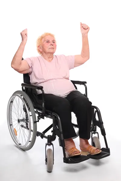 Anciana parapléjica sentada en silla de ruedas sobre un blanco . — Foto de Stock