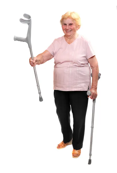 Happy elderly woman with her crutches. — Stock Photo, Image