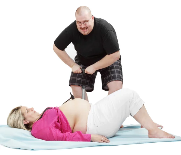 Funny picture of a overweight man pumping big belly his wife. — Stock Photo, Image