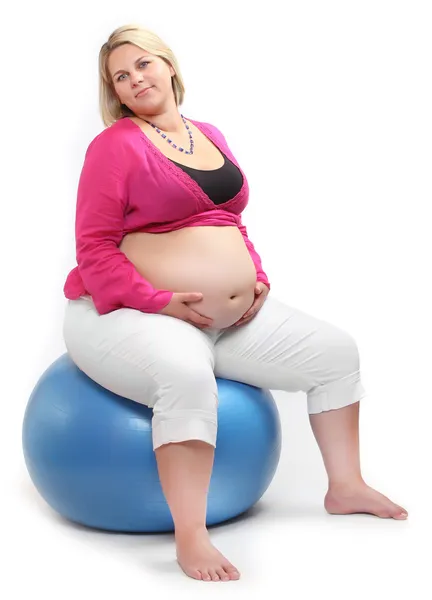 Overgewicht vrouw aanbrengen op een blauwe bal. — Stockfoto