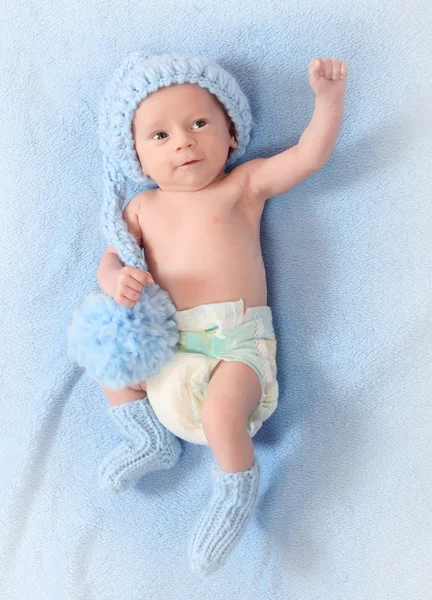Foto de moda de un lindo bebé con divertido sombrero de punto y calcetines para el clima frío —  Fotos de Stock