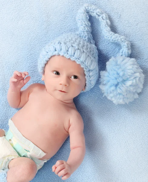 Foto de moda de um bebê bonito com chapéu de malha engraçado e meias para o tempo frio — Fotografia de Stock
