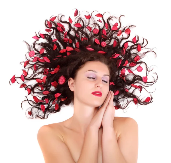 Vacker ung kvinna med blommor på hennes långa hår — Stockfoto