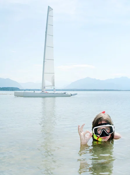 Young girl snorkeling in sea against her sail boat. — Stock Photo, Image